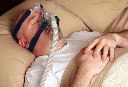 Man Wearing CPAP Device